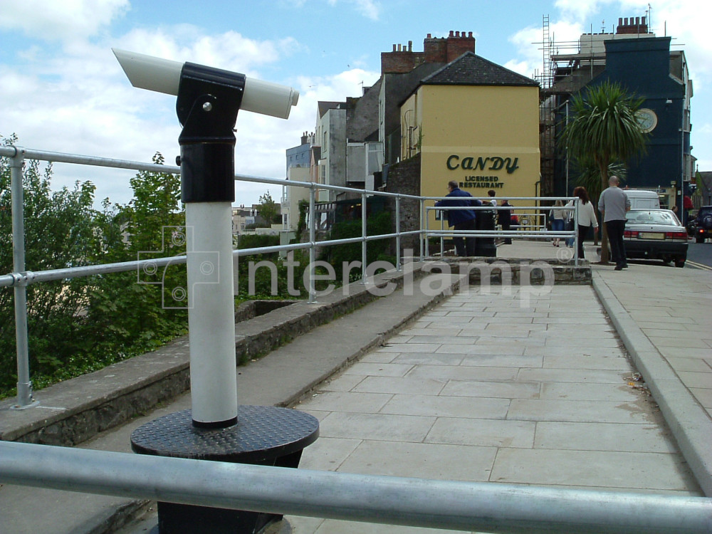 Close-up of an Interclamp tube clamp handrail installation on a seaside pier, showcasing its durable construction and the sparkling sea below.